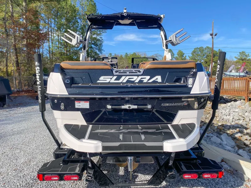 Slide: The Image of Rear view of a 2024 Supra SL boat on gravel. - 9