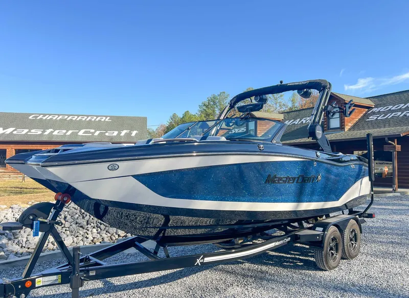 Slide: The Image of 2024 MasterCraft X22 boat on trailer, blue sky. - 3