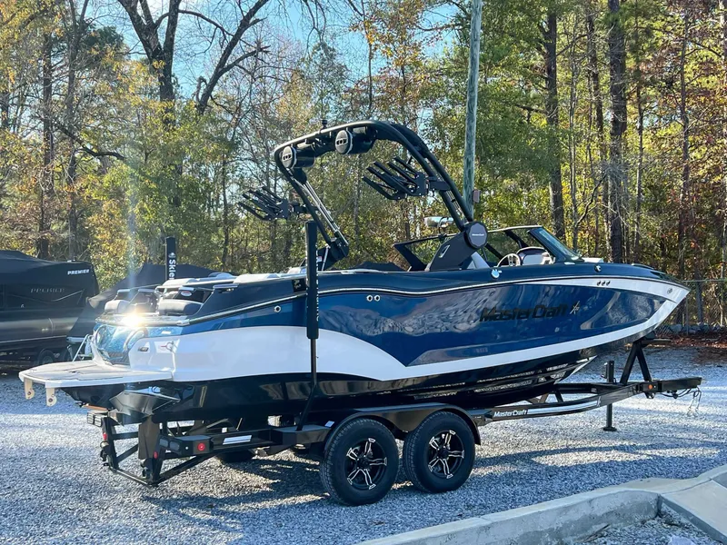 Slide: The Image of 2024 MasterCraft X22 boat on trailer outdoors. - 7