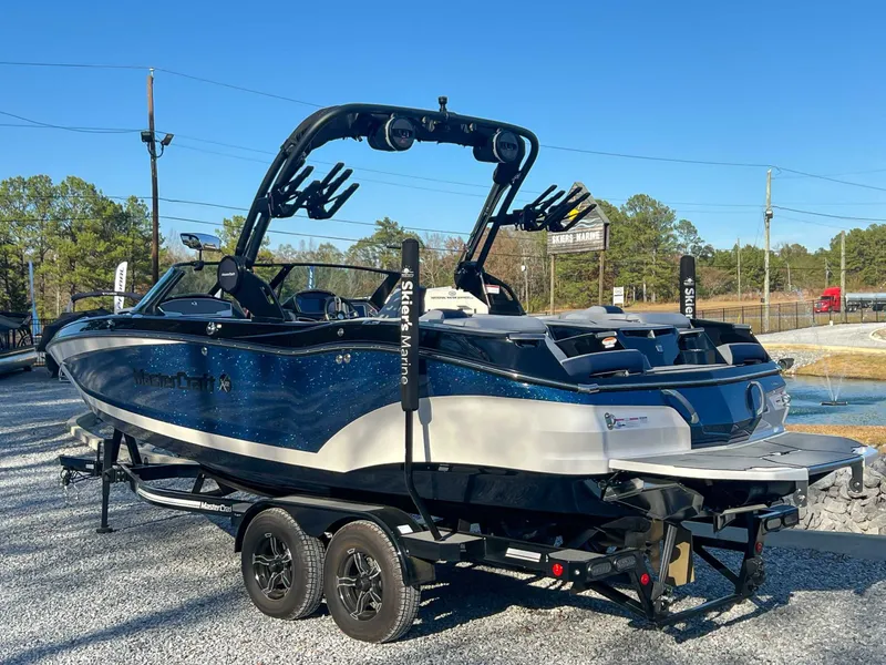 Slide: The Image of 2024 MasterCraft X22 boat on trailer, blue sky. - 8