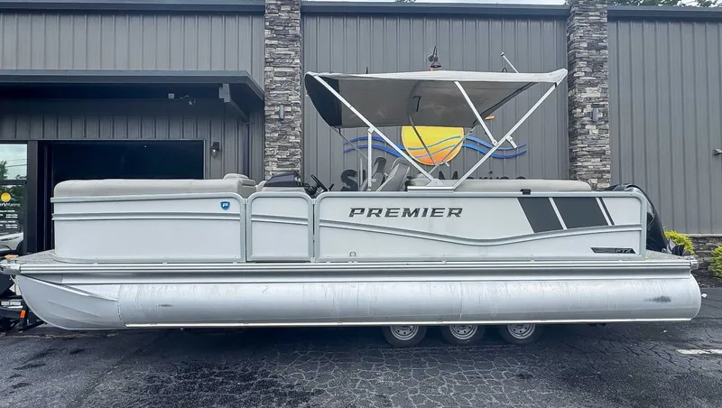 The Image of 2024 Premier 230 SunSation RF pontoon boat in front of gray building. - 1