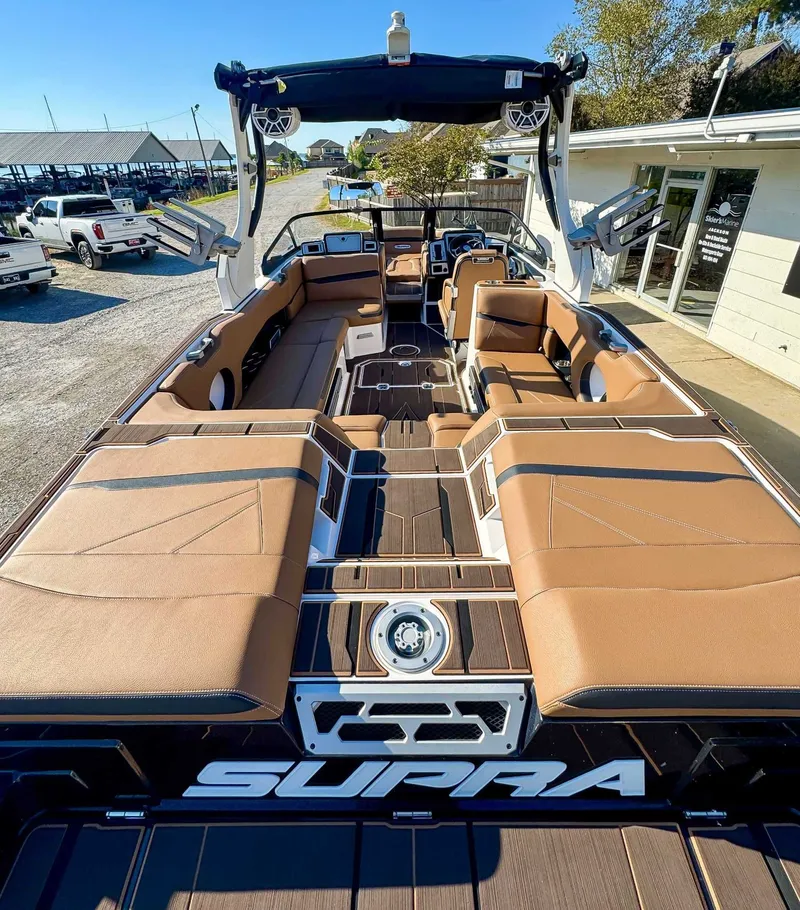 Slide: The Image of Interior of a 2023 Supra SL boat with brown seating. - 10