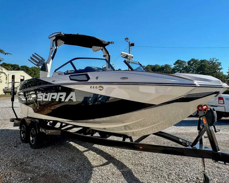 Slide: The Image of 2023 Supra SL boat on trailer outdoors. - 5
