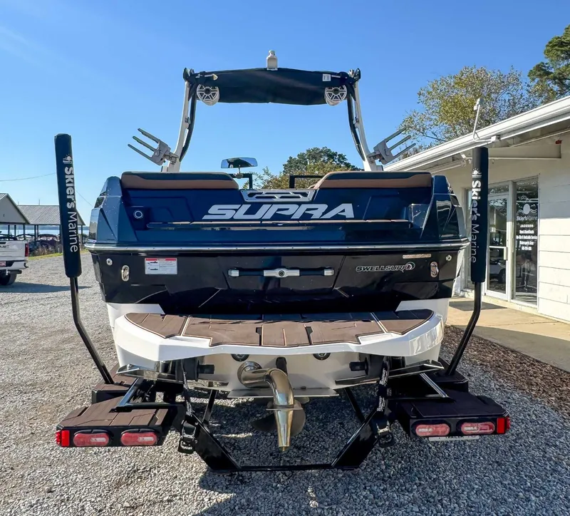 Slide: The Image of Rear view of a 2023 Supra SL boat on gravel surface. - 9