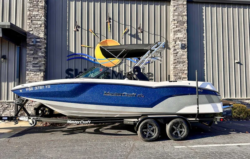 The Image of 2021 MasterCraft NXT22 boat parked in front of a building. - 1