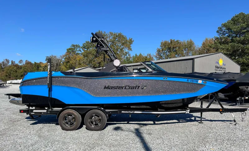 The Image of 2024 MasterCraft XT24 boat on trailer outdoors. - 1