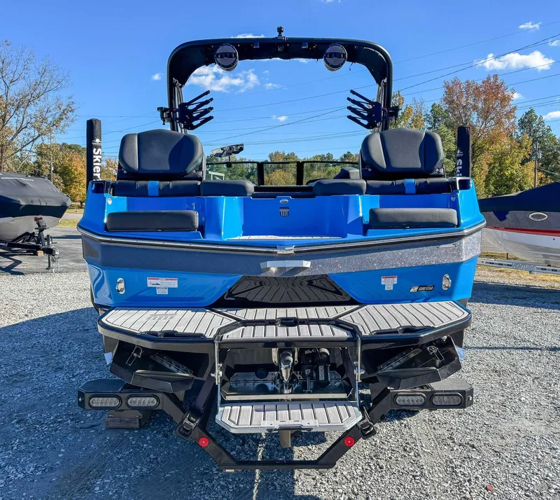 Slide: The Image of Rear view of blue 2024 MasterCraft XT24 boat on gravel. - 10