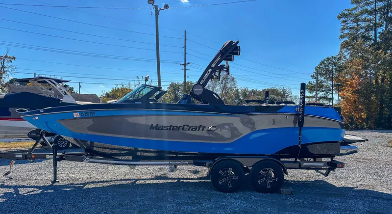 Slide: The Image of 2024 MasterCraft XT24 boat on trailer outdoors. - 6