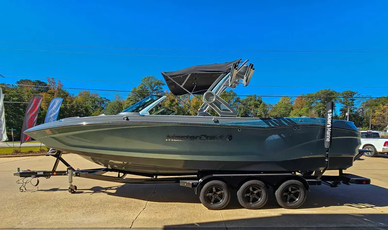 Slide: The Image of 2023 MasterCraft X26 boat on trailer under clear sky. - 6