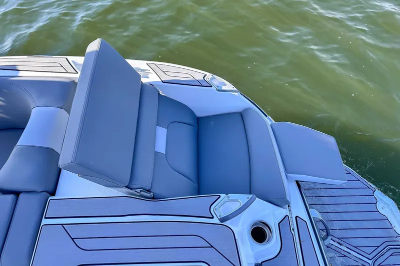 Slide: The Image of MasterCraft X24 2024 boat rear seating area on water. - 10