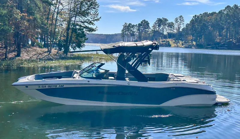 Slide: The Image of 2024 MasterCraft X24 boat on a serene lake. - 6