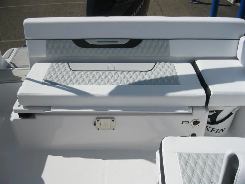 Slide: The Image of 2024 Blackfin 232 DC boat interior with white and gray seating, steering console, and Yeti cooler. - 11