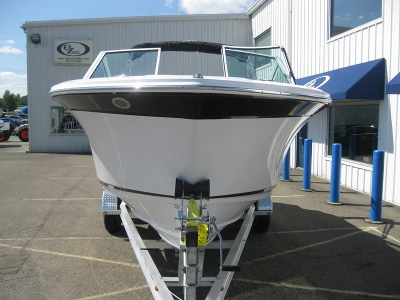 Slide: The Image of 2024 Blackfin 232 DC boat on a trailer outside a dealership. - 2