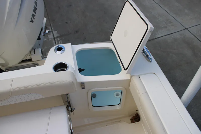 Slide: The Image of 2026 Scout 220 XSF boat interior with open storage compartment and cup holders. - 9