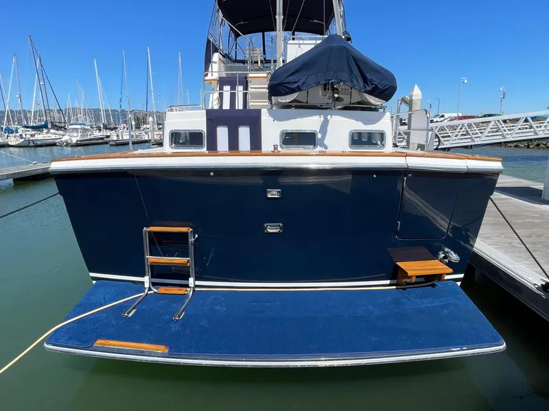 Slide: The Image of 1997 Sabre Cockpit Motor Yacht docked, featuring a blue hull and swim platform. - 11