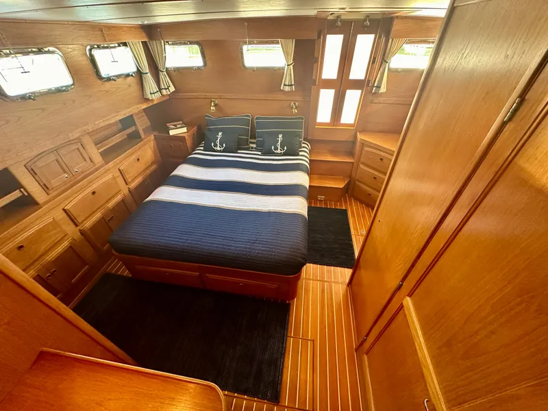 Slide: The Image of Luxurious 1997 Sabre Cockpit Motor Yacht bedroom with wood paneling and nautical decor. - 23