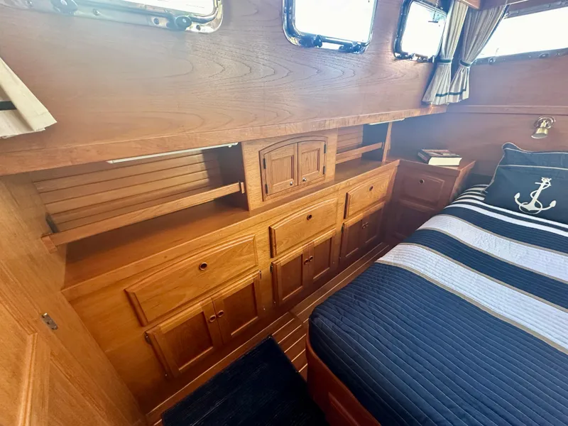 Slide: The Image of Interior of 1997 Sabre Cockpit Motor Yacht with wooden cabinetry and nautical-themed bedding. - 25