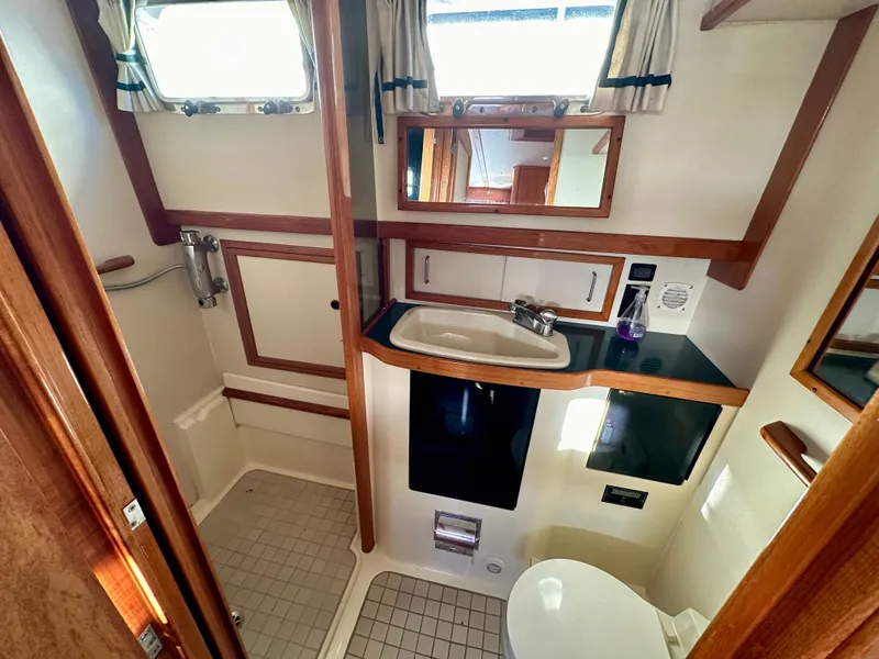 Slide: The Image of 1997 Sabre Cockpit Motor Yacht bathroom with sink, mirror, and shower area. - 28