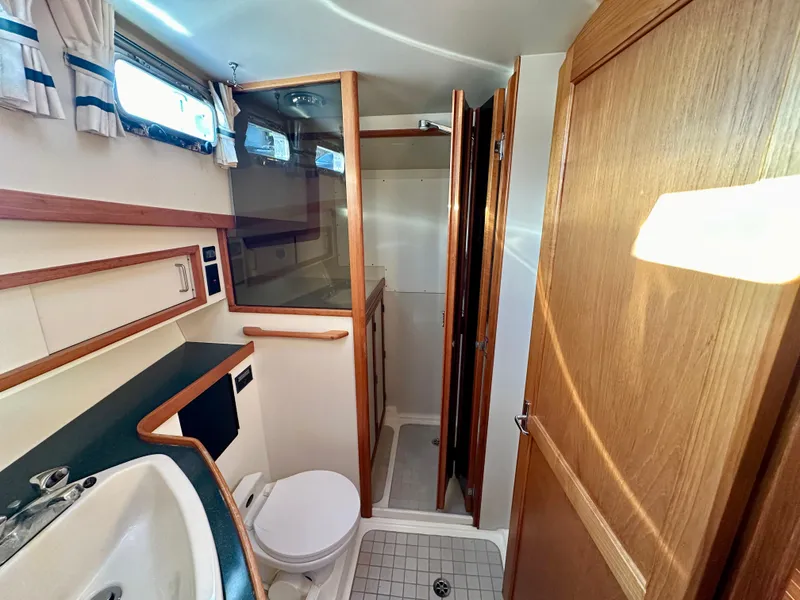 Slide: The Image of 1997 Sabre Cockpit Motor Yacht bathroom with shower, sink, and wooden cabinetry. - 31