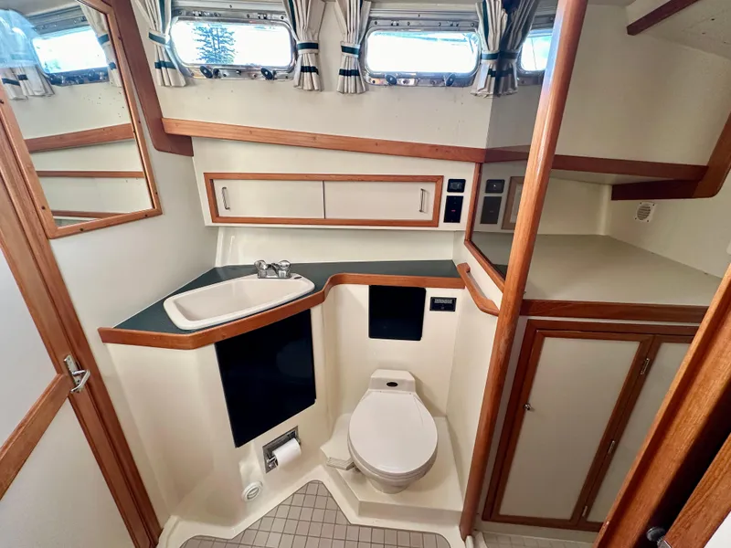 Slide: The Image of 1997 Sabre Cockpit Motor Yacht bathroom with sink, toilet, and storage cabinets. - 32