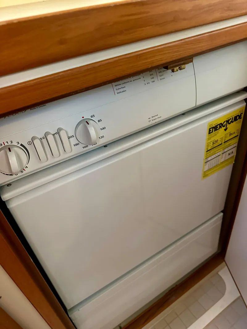 Slide: The Image of Built-in dishwasher in 1997 Sabre Cockpit Motor Yacht, featuring wood trim and energy guide label. - 33