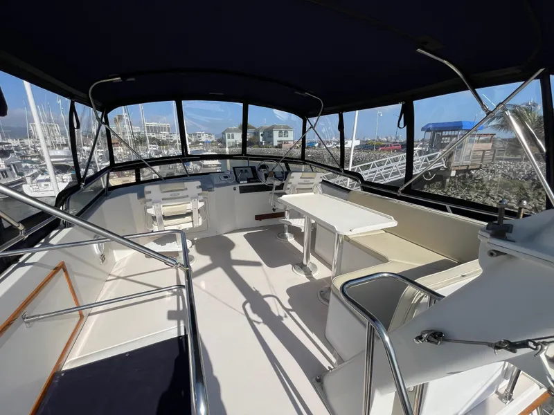 Slide: The Image of 1997 Sabre Cockpit Motor Yacht interior with helm, seating, and table, docked at marina. - 40