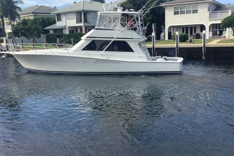 Slide: The Image of 1994 Viking 50' Convertible Sportfish yacht cruising near waterfront homes. - 11