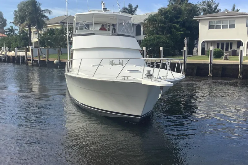 Slide: The Image of 1994 Viking 50' Convertible Sportfish yacht on a calm waterway near waterfront homes. - 12