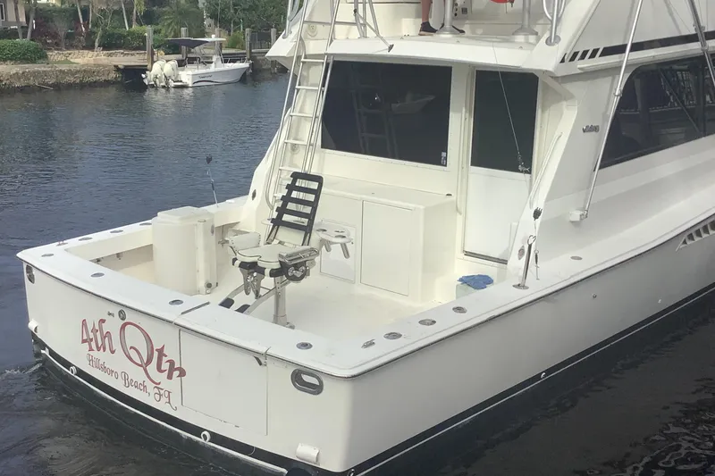 Slide: The Image of 1994 Viking 50' Convertible Sportfish boat docked, featuring fishing chair and ladder. - 13