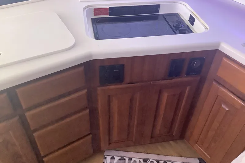 Slide: The Image of 1994 Viking 50' Convertible Sportfish kitchen with wooden cabinets and built-in stove. - 20