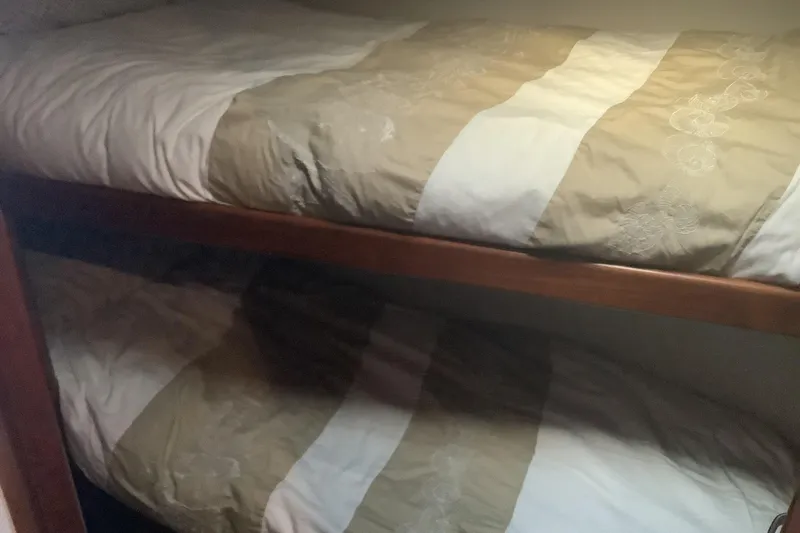 Slide: The Image of Bunk beds in 1994 Viking 50' Convertible Sportfish cabin, featuring beige and white bedding. - 24