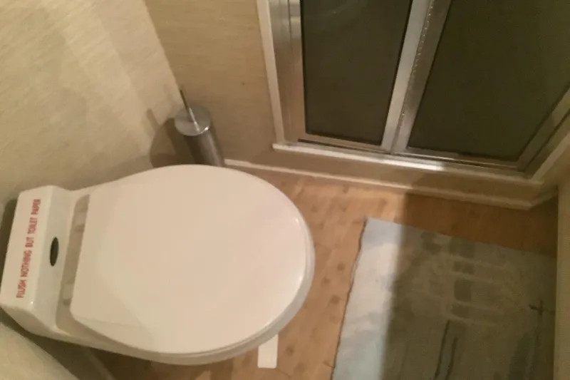 Slide: The Image of Bathroom interior of 1994 Viking 50' Convertible Sportfish yacht, featuring toilet and shower. - 26