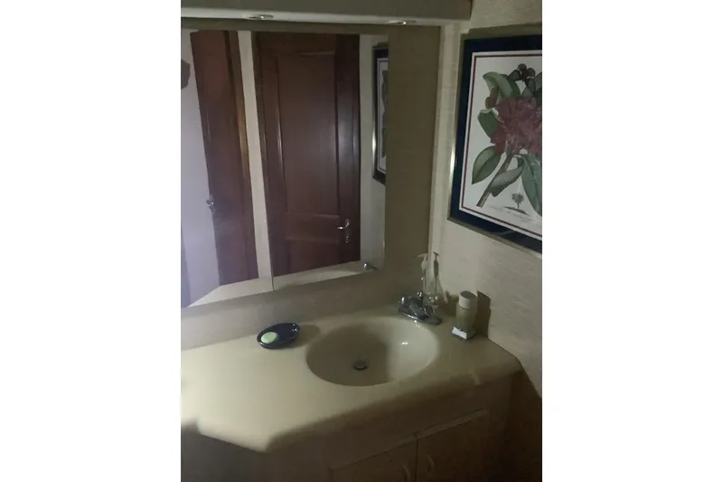 Slide: The Image of Bathroom vanity on 1994 Viking 50' Convertible Sportfish with mirror and floral artwork. - 27