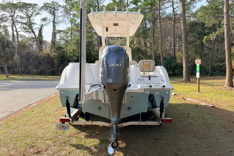 Slide: The Image of 2022 Sea Fox 228 Commander boat with Yamaha 200 engine, parked in a wooded area. - 2