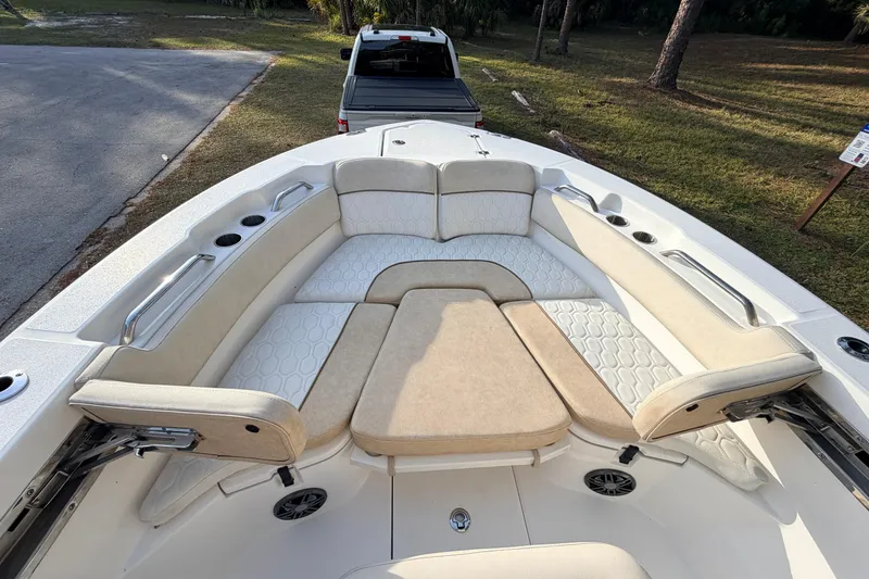 Slide: The Image of 2022 Sea Fox 228 Commander boat with spacious seating and cup holders, parked near a truck. - 24