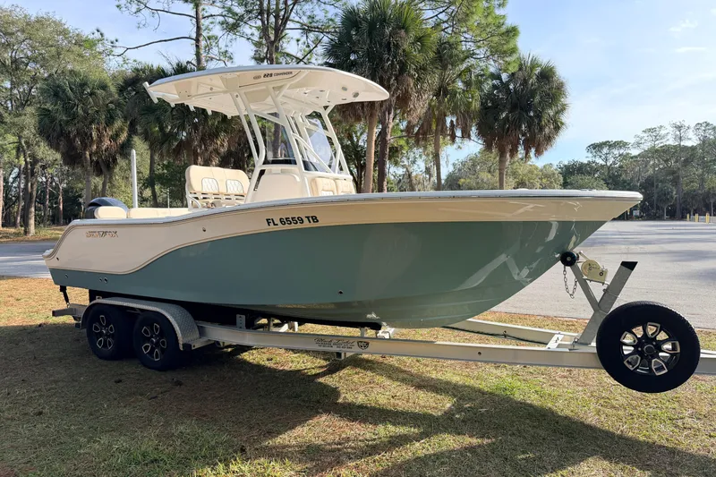 Slide: The Image of 2022 Sea Fox 228 Commander boat on trailer, parked near palm trees. - 4
