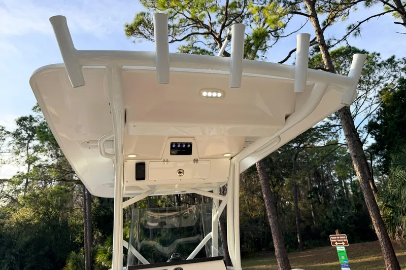 Slide: The Image of 2022 Sea Fox 228 Commander boat with T-top and rod holders in a wooded area. - 68