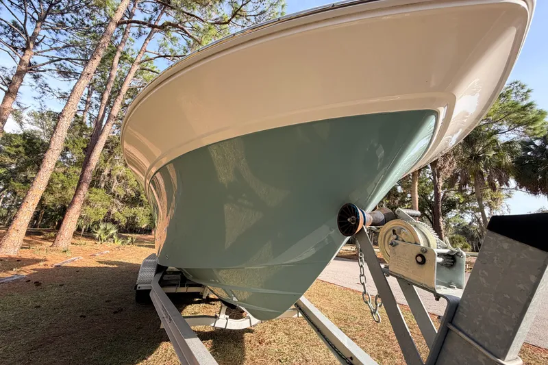 Slide: The Image of 2022 Sea Fox 228 Commander boat on trailer, surrounded by trees. - 7