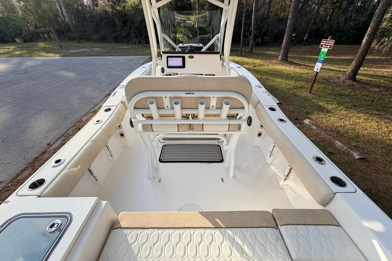Slide: The Image of 2022 Sea Fox 228 Commander boat interior with seating and console, parked near forest. - 92
