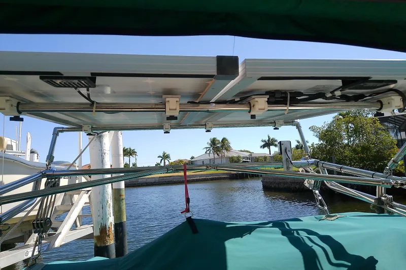 Slide: The Image of 1991 Hunter 30 sailboat with solar panels docked by a canal. - 10