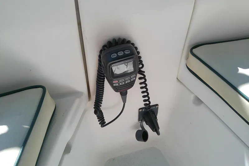 Slide: The Image of VHF radio installed on a 1991 Hunter 30 sailboat, with cushioned seating nearby. - 17