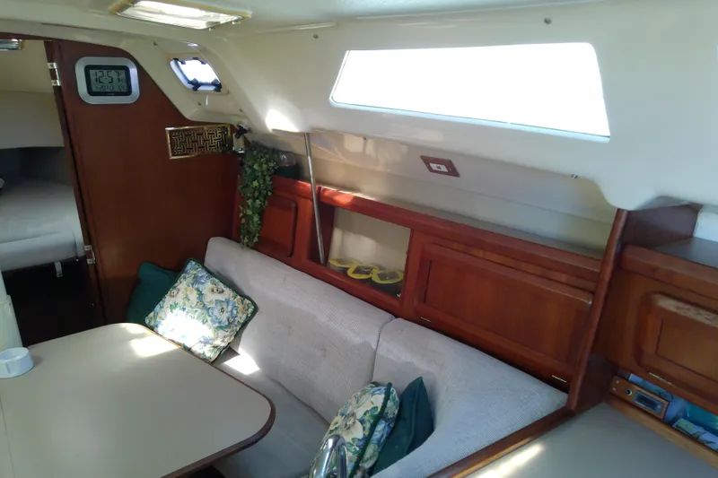 Slide: The Image of Cozy interior of a 1991 Hunter 30 sailboat with seating and wooden cabinetry. - 23
