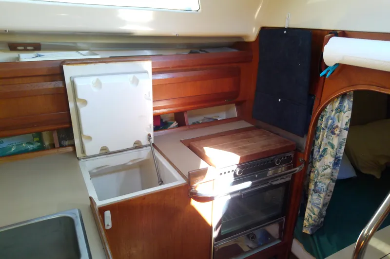 Slide: The Image of Interior of a 1991 Hunter 30 sailboat kitchen with stove and storage. - 25