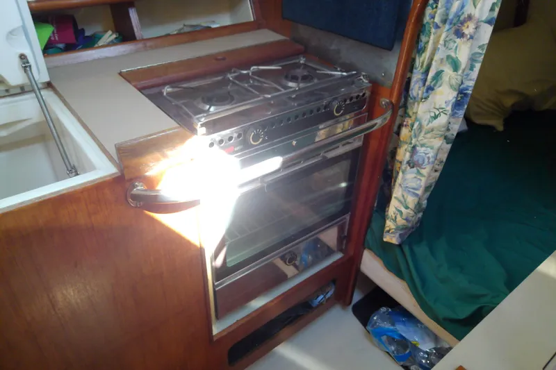 Slide: The Image of 1991 Hunter 30 yacht interior with stove and oven in compact kitchen area. - 28