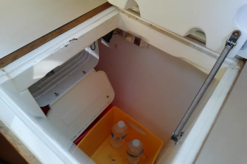 Slide: The Image of Storage compartment with water bottles in a 1991 Hunter 30 sailboat. - 29