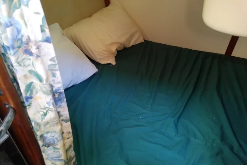 Slide: The Image of Cozy cabin bed in a 1991 Hunter 30 sailboat with floral curtain. - 30