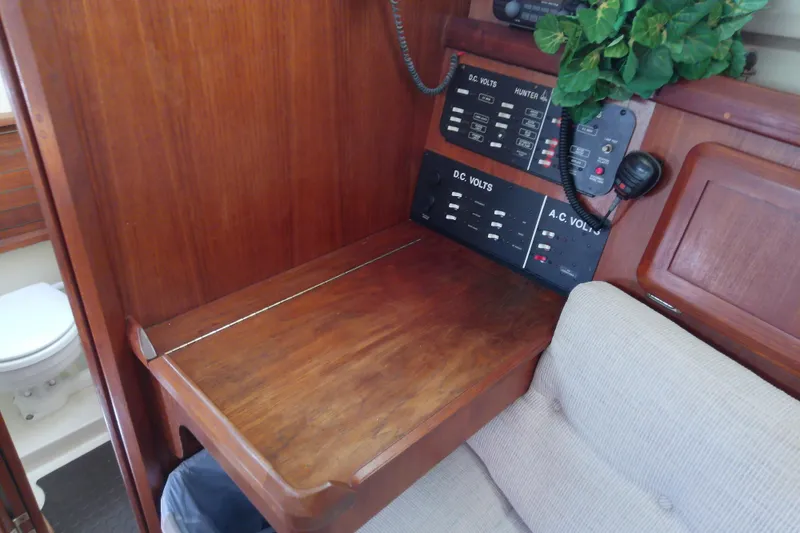 Slide: The Image of Interior of a 1991 Hunter 30 sailboat with control panels and wooden desk. - 33