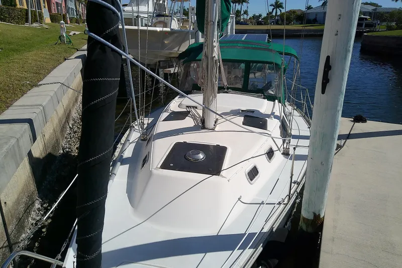 Slide: The Image of 1991 Hunter 30 sailboat docked by a canal with green canopy. - 4