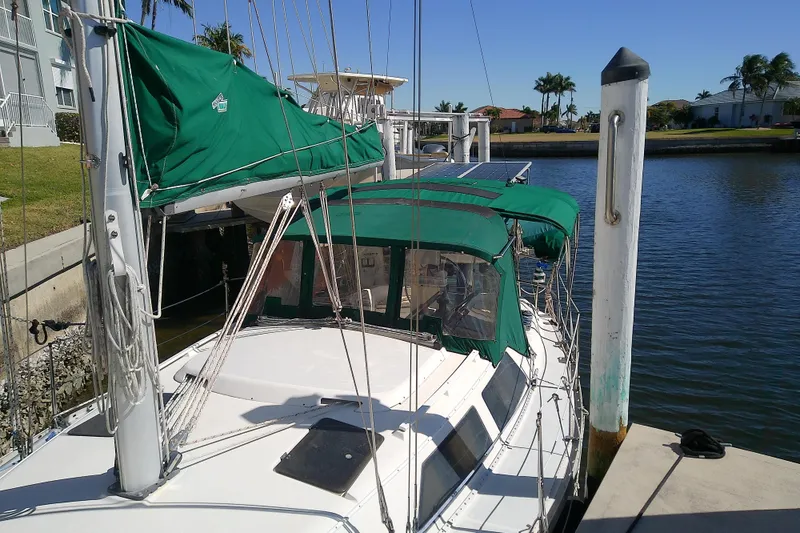 Slide: The Image of 1991 Hunter 30 sailboat docked with green covers and clear skies. - 5