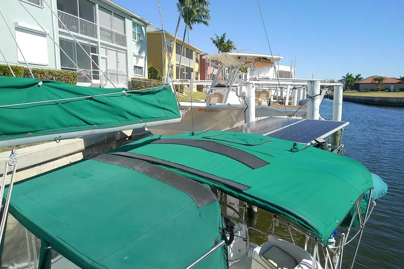Slide: The Image of Hunter 30 sailboat from 1991 docked near waterfront homes, featuring green covers. - 7